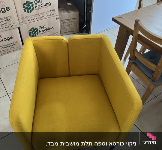 כורסה צהובה על רצפה מרוצפת עם דלי ירוק